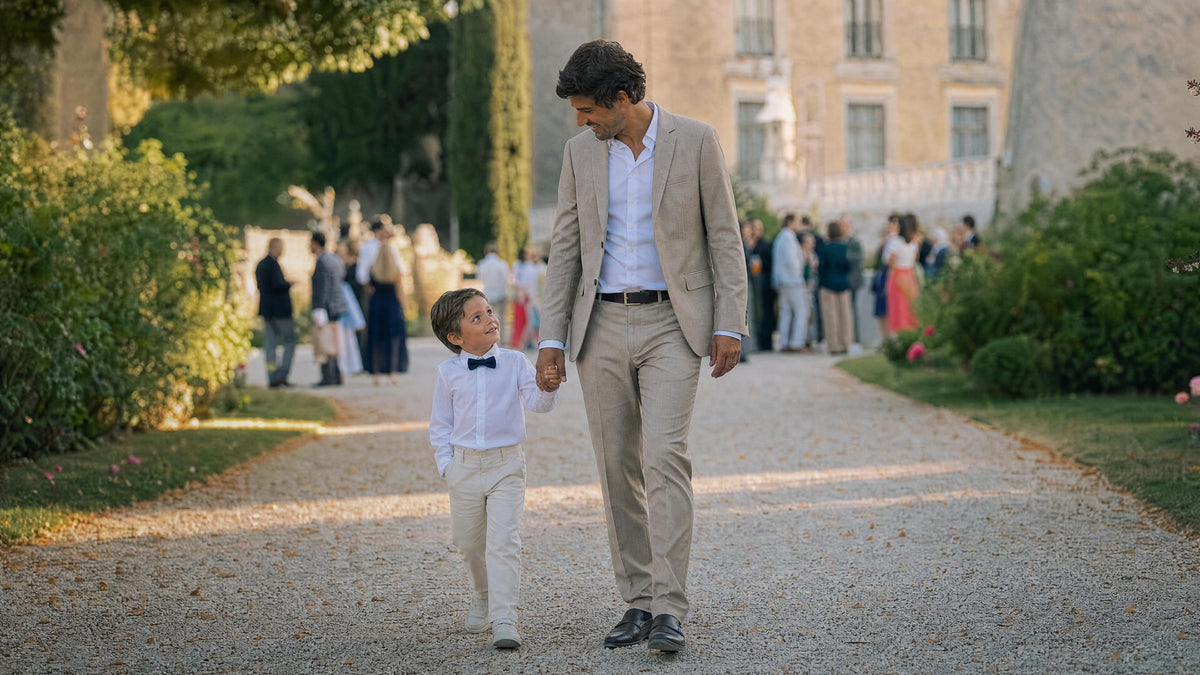 Enfant habillé pour un mariage marchant avec un adulte, tenue élégante et confortable. Immagine