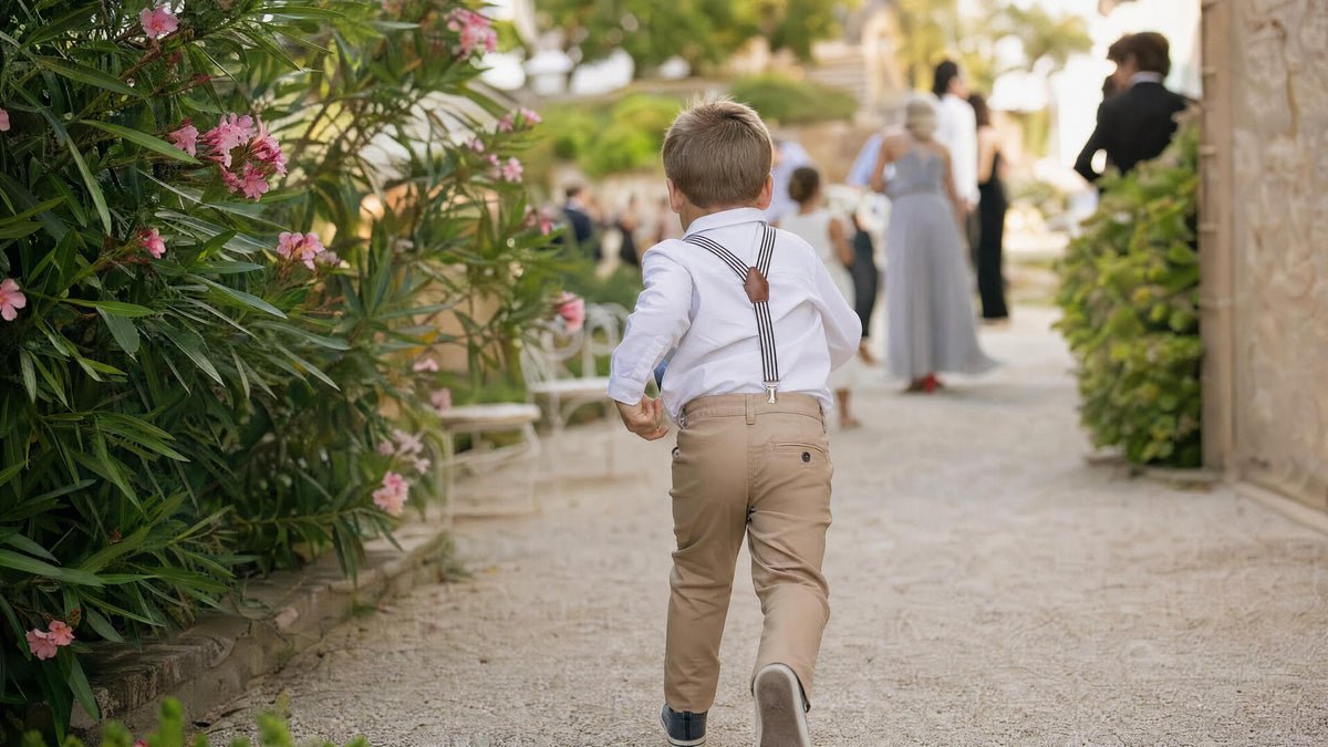 Enfant portant des bretelles pour une cérémonie, tenue élégante et naturelle. Immagine